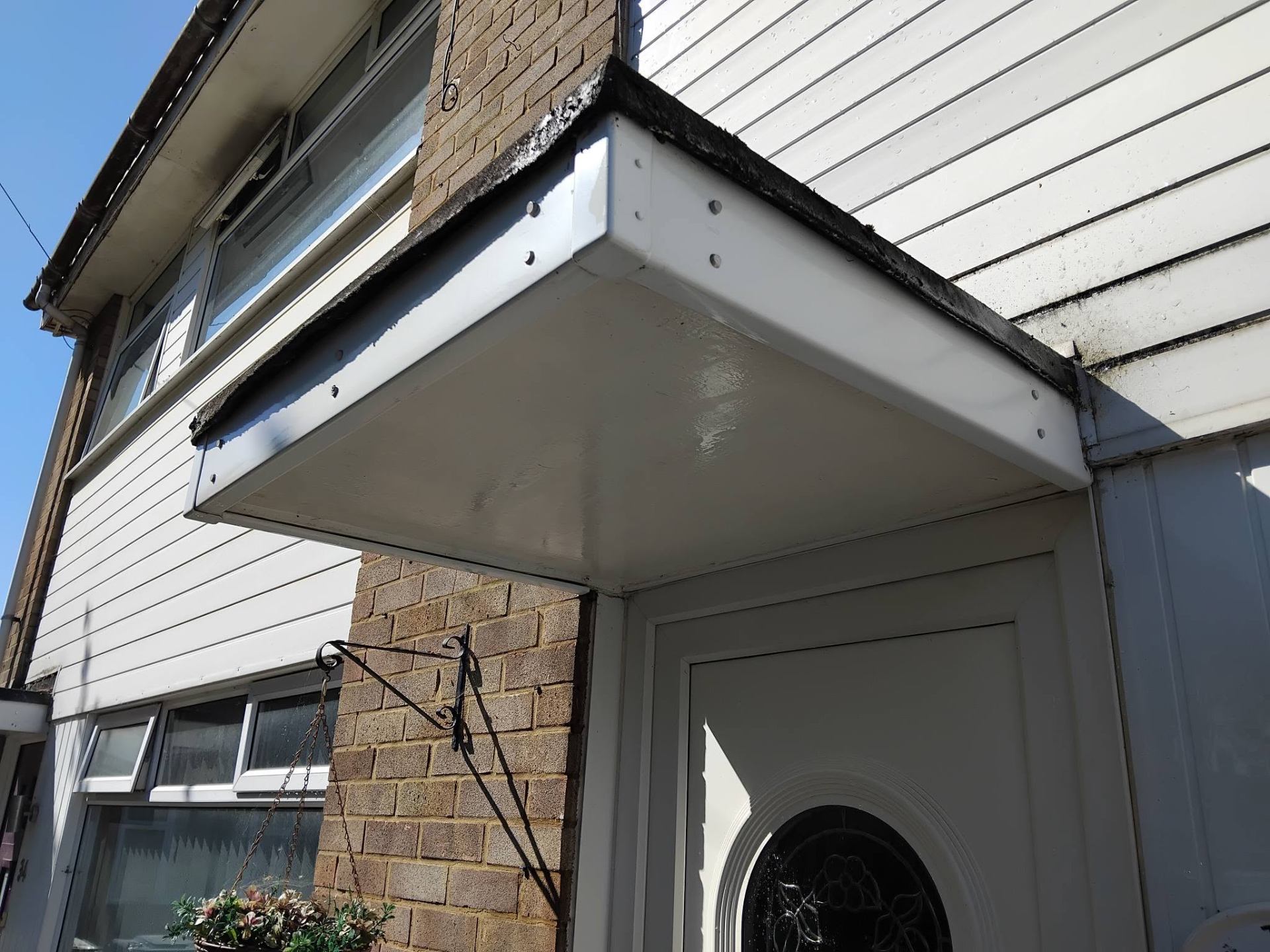 Porch roof after cleaning — bright white uPVC restored